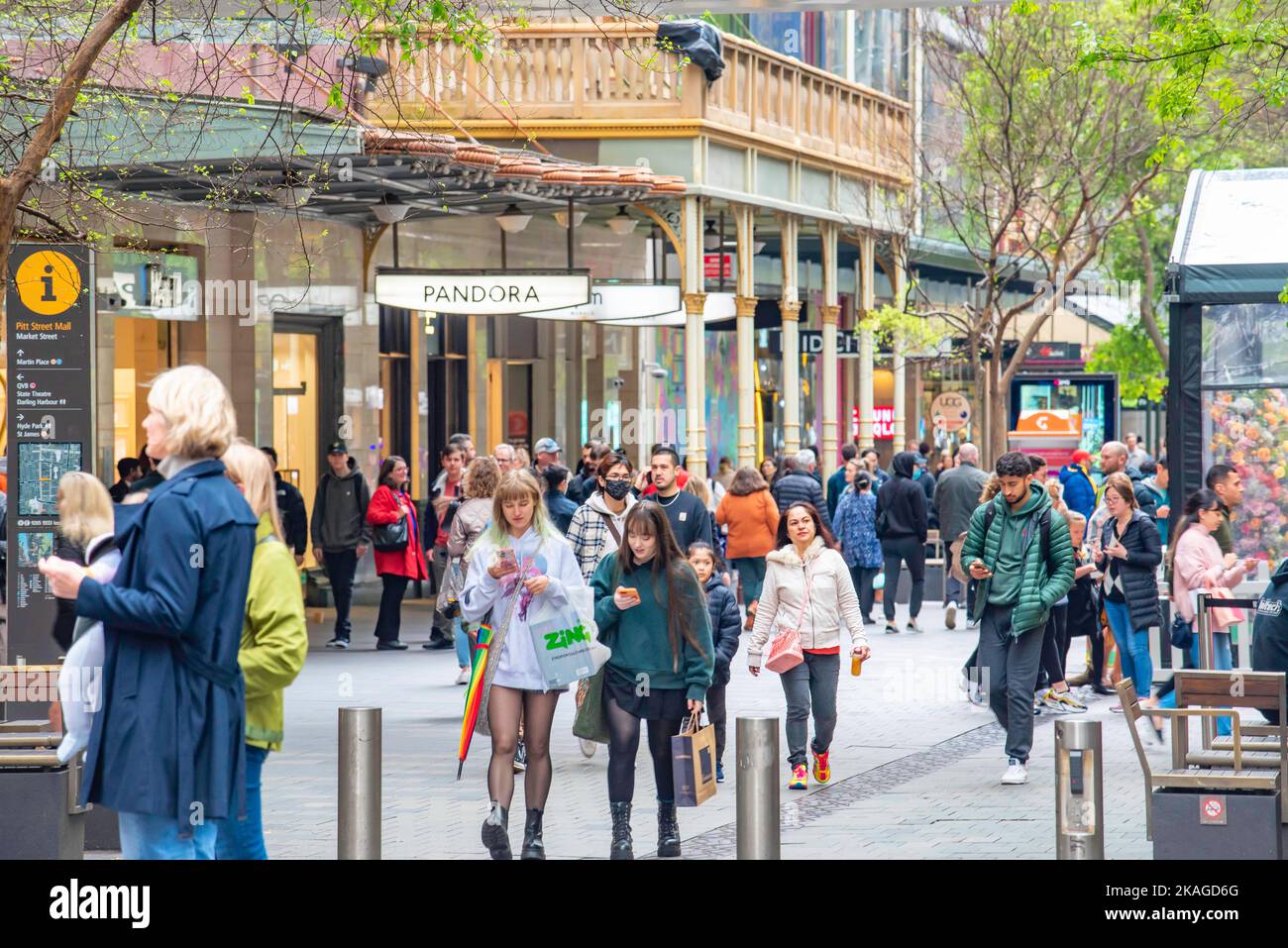 Menschen, die durch die Pitt Street Mall im Einkaufsviertel von Sydney, Australien, laufen und ihre Handys ansehen oder lesen Stockfoto