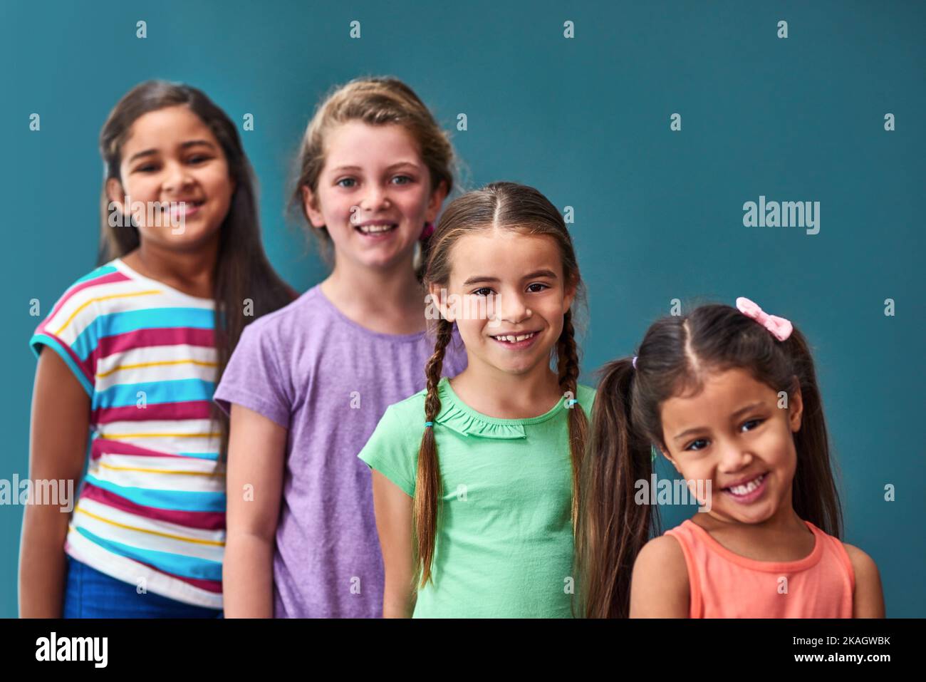 Die größte Gruppe von Kindern. Studioportrait einer vielfältigen Gruppe von Kindern, die vor blauem Hintergrund posieren. Stockfoto