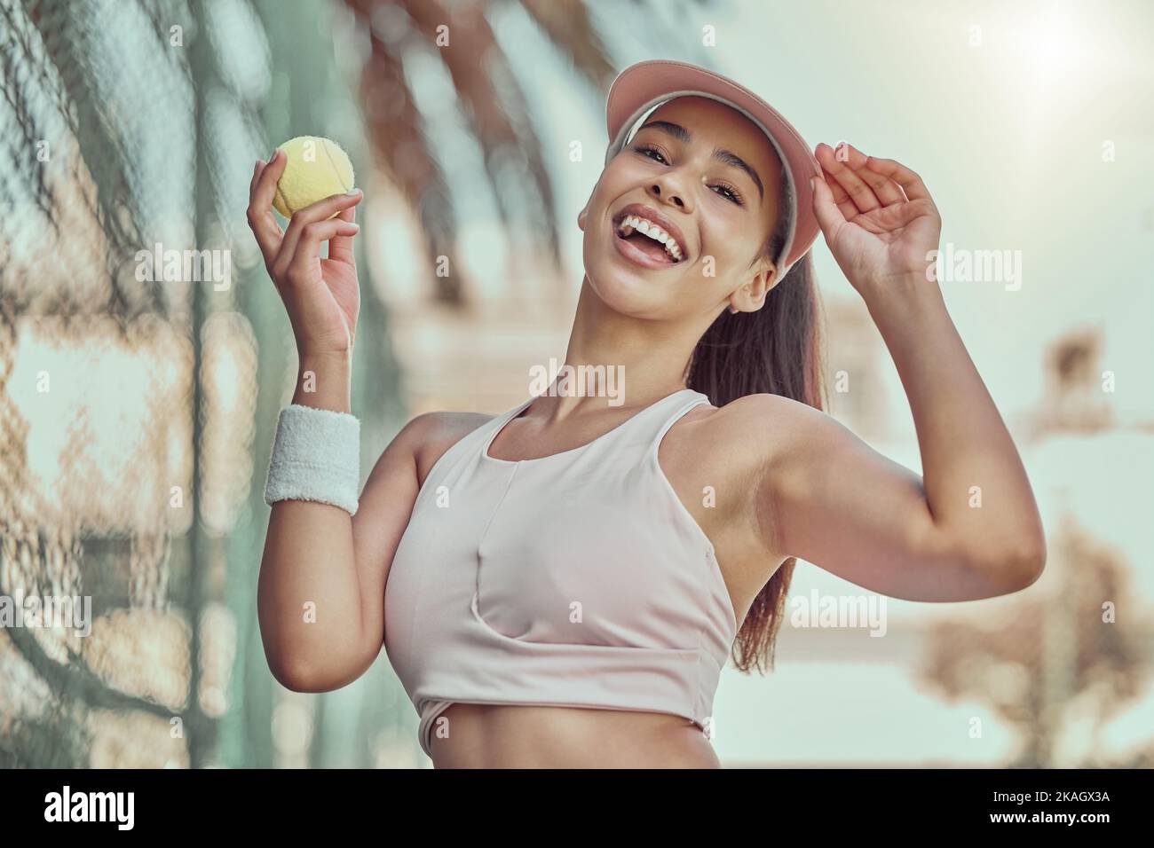 Fröhlich, Frau und Tennisball mit Lächeln für Sport, Bewegung oder Fun-Workout im Sommer im Freien. Porträt der Frau in der Sportfitness lächelnd für Stockfoto
