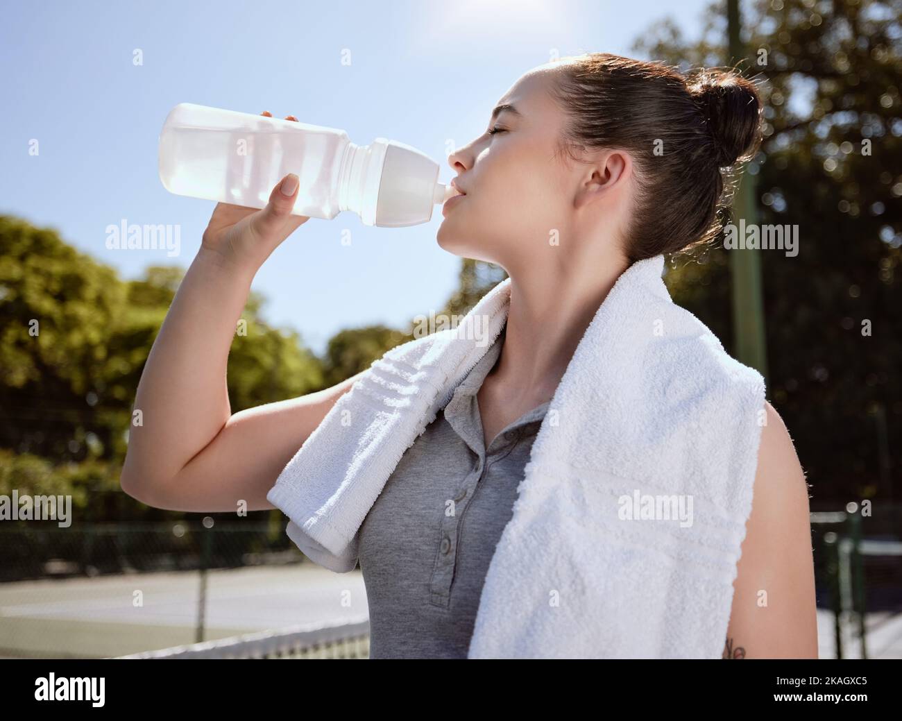 Fitness, Frau mit Wasserflasche und Hydrat nach dem Training, Handtuch und draußen trinken. Sport, gesund und aktiv mit Pause vom Training Stockfoto