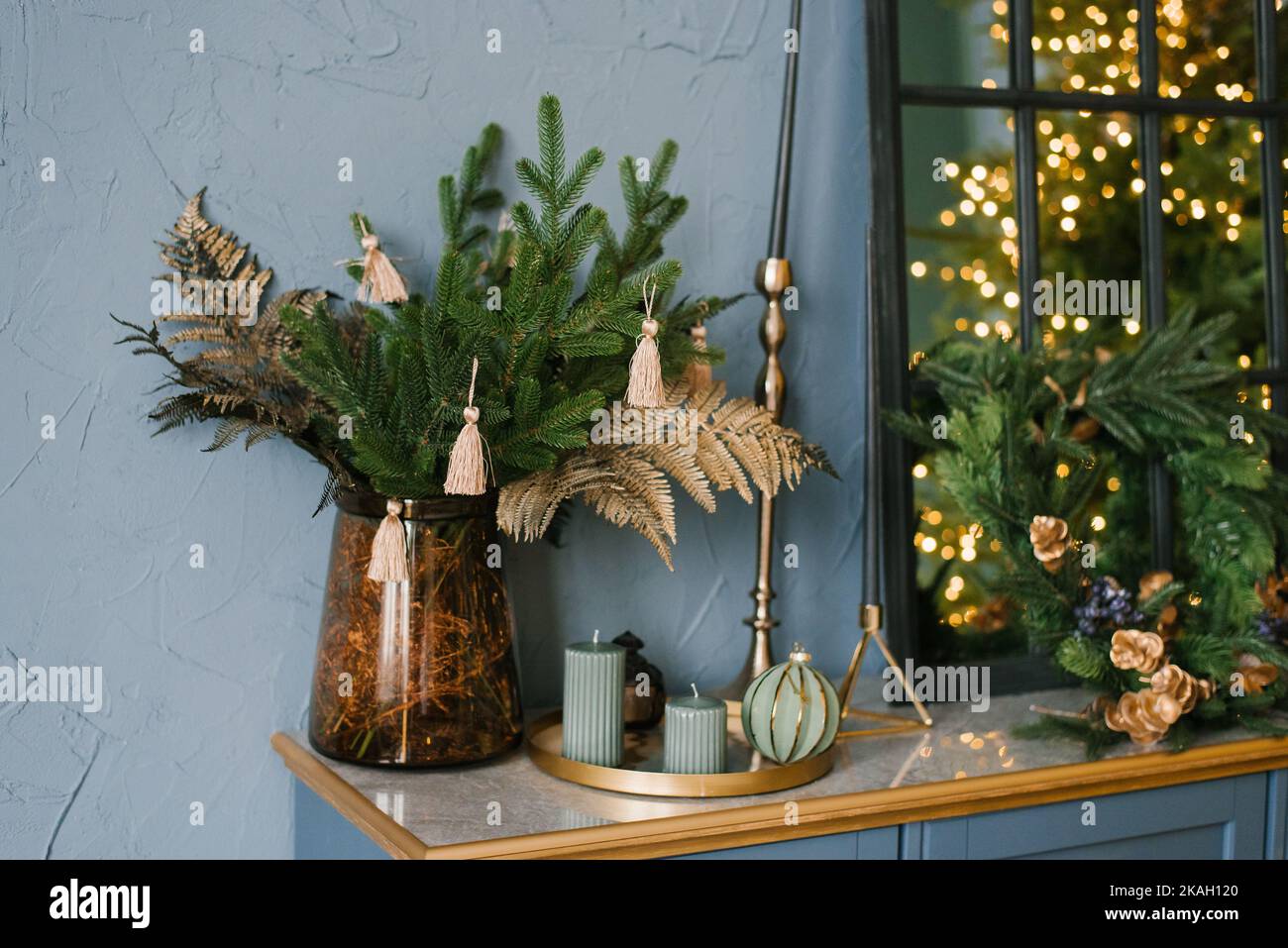 Weihnachtsdekor im Wohnzimmer, Christbaumzweige, Kerzen auf der blauen Kommode Stockfoto