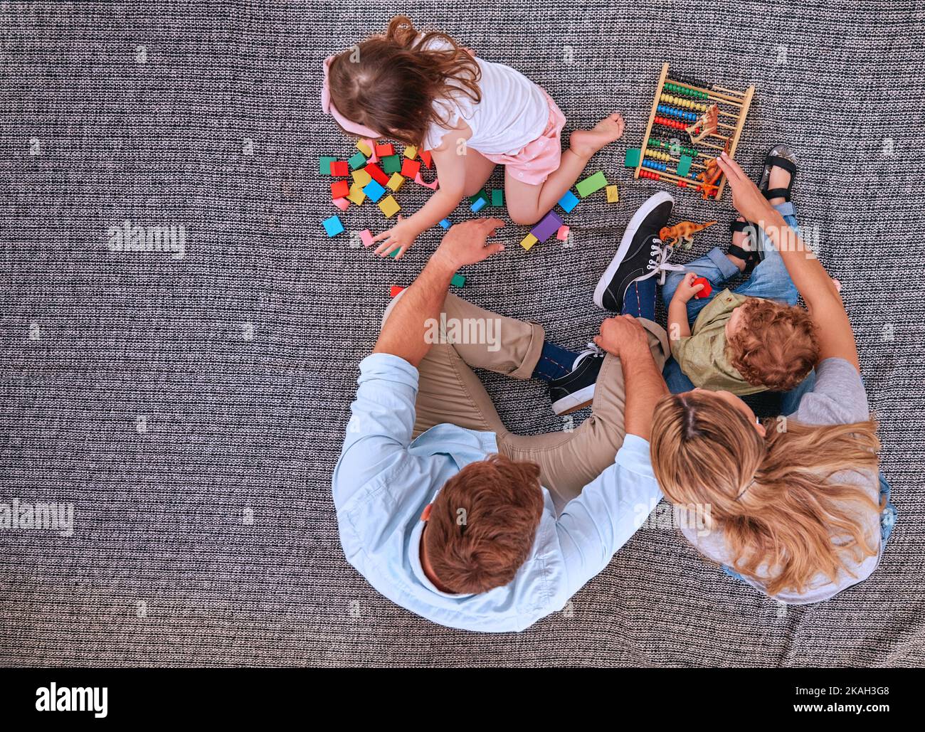 Familie, Kinder und Lernen mit Schulspielzeug, Blöcken und Abakus für Farbspiel mit Mama und Papa auf dem Boden. Männer und Frauen Eltern mit Kindern für Stockfoto