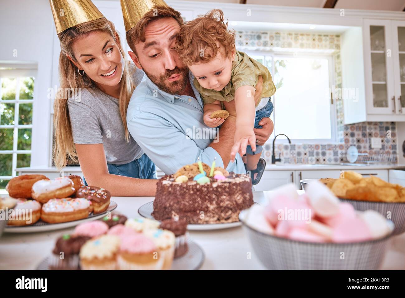 Familie, Geburtstag und Kind feiern mit Party und Kuchen zu Hause und dabei Spaß haben. Mutter, Vater und kleiner Junge feiern mit einer Geburtstagsfeier Stockfoto