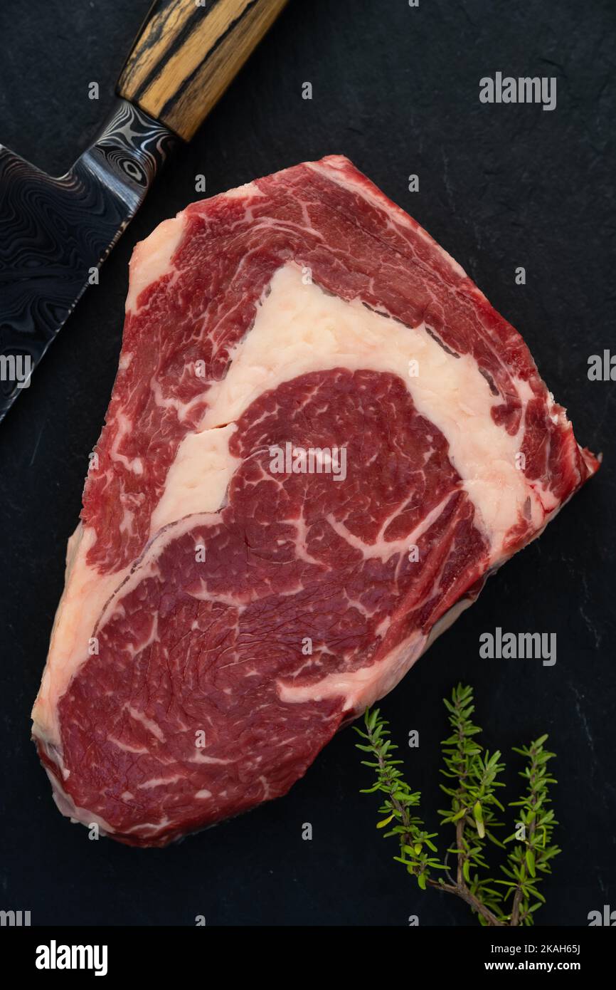 Wagyu Beef Ribeye Steak Raw Dry Aged auf schwarzem Hintergrund Stockfoto