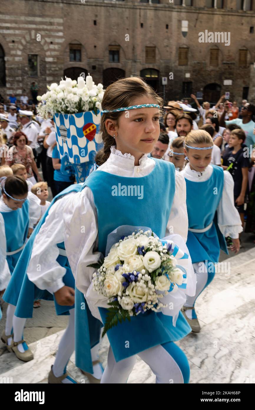 Siena, Toskana, Italien - 15 2022. August: Flower Girl of the Onda oder Wave Contrada bei der Cero Votivo Prozession im Palio di Siena in der Toskana, Italien Stockfoto