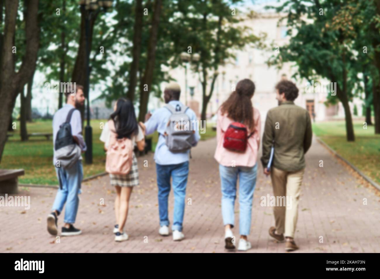Verschwommenes Bild von Studenten plaudern, während sie durch den Park gehen. Stockfoto