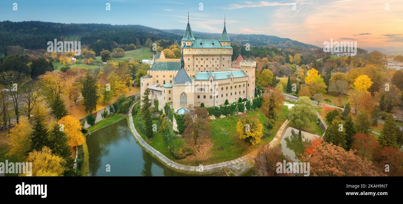 Schloss Bojnice. Panorama-Luftaufnahme eines neogotischen romantischen Märchenschlosses in einem bunten Herbstgarten. Festung, Türme und Wassergraben. U Stockfoto