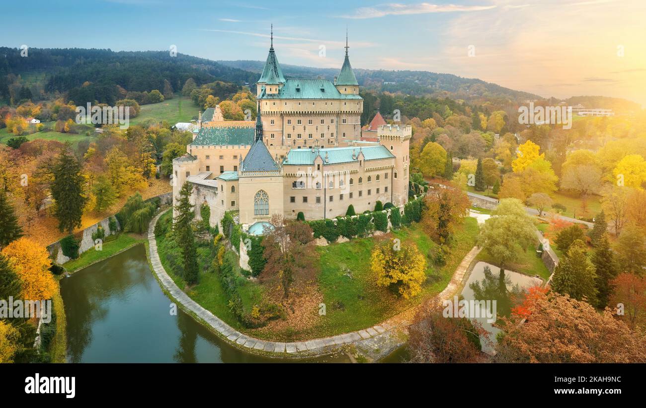 Schloss Bojnice. Panorama-Luftaufnahme eines neogotischen romantischen Märchenschlosses in einem bunten Herbstgarten. Festung, Türme und Wassergraben. U Stockfoto