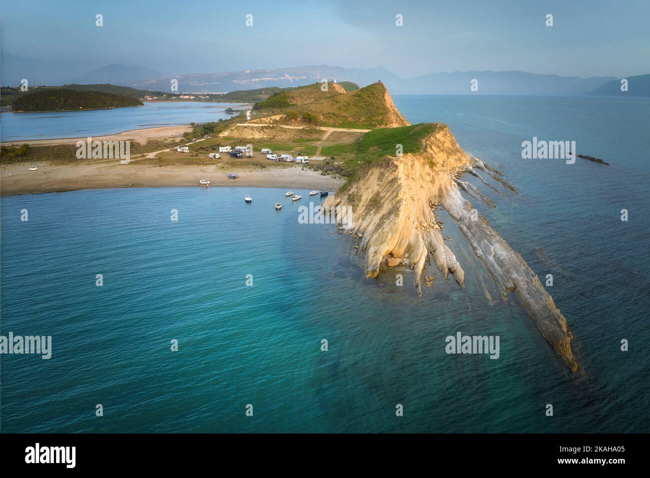 Luftaufnahme einer Gruppe von Wohnwagen und Booten in einer geschützten Bucht mit einem Sandstrand. Kostenloses Camping am Meer. Unabhängiges Wohnen, van-Life-Konzept. A Stockfoto