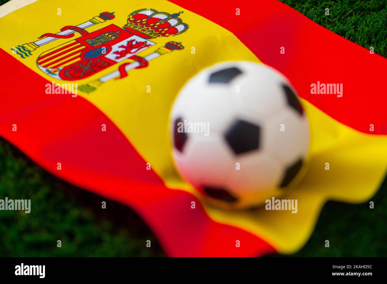 Spanische Fußballnationalmannschaft. Nationalflagge auf grünem Gras und Fußball. Fußball-Wallpaper für Meisterschaft und Turnier im Jahr 2022. Internationale Welt Stockfoto