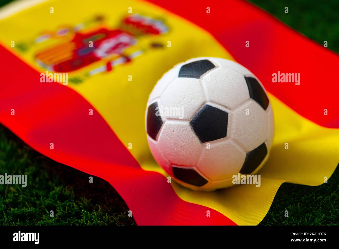 Spanische Fußballnationalmannschaft. Nationalflagge auf grünem Gras und Fußball. Fußball-Wallpaper für Meisterschaft und Turnier im Jahr 2022. Internationale Welt Stockfoto