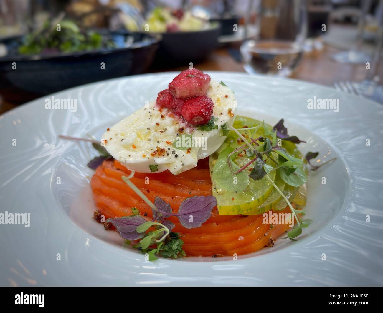 Nahaufnahme eines Tomaten- und Mozzarella-Salats mit Erdbeere und Mikroblatt-Garnitur Stockfoto