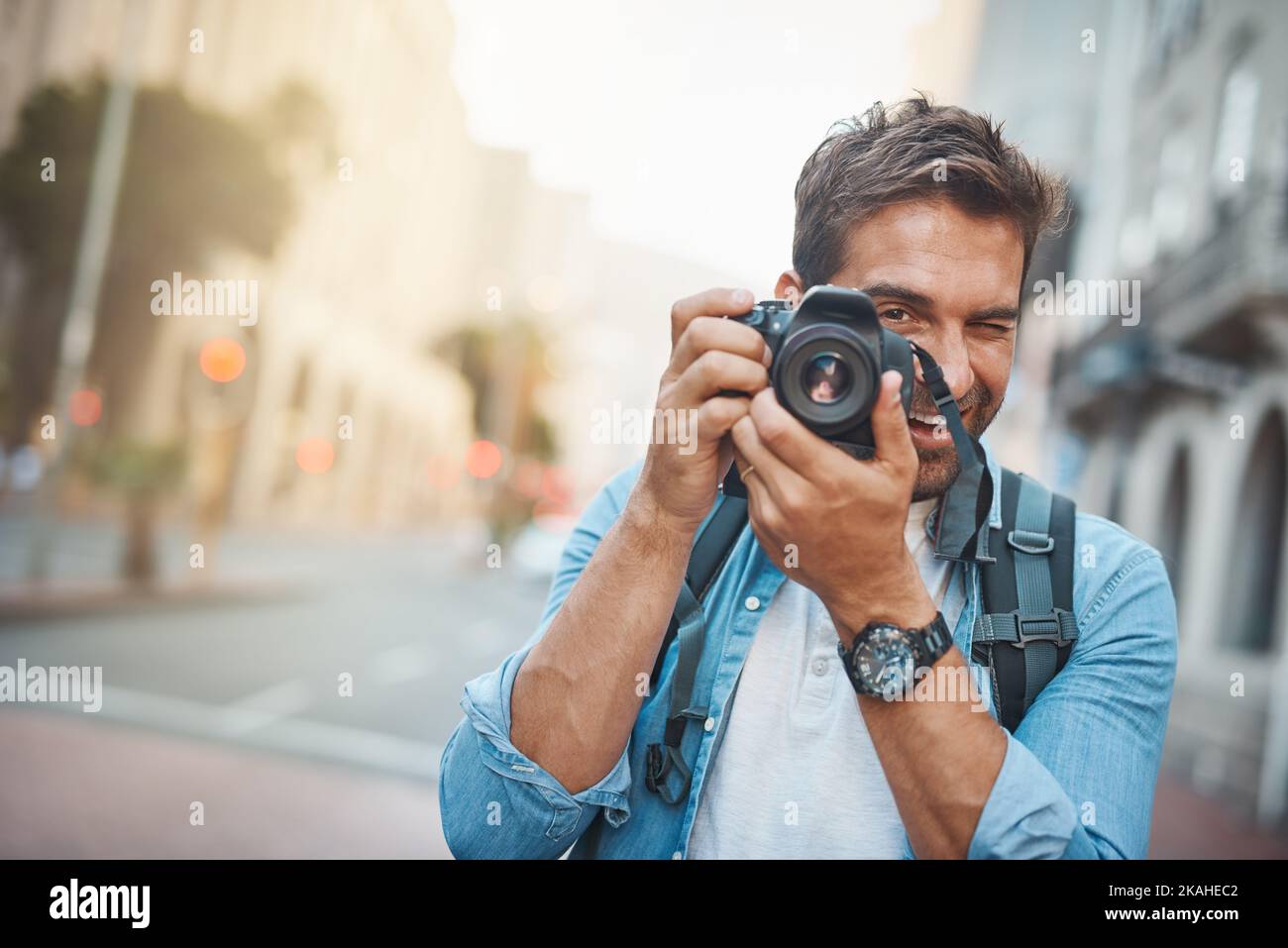 Ein junger Mann, der während der Erkundung einer fremden Stadt Fotos gemacht hat. Stockfoto