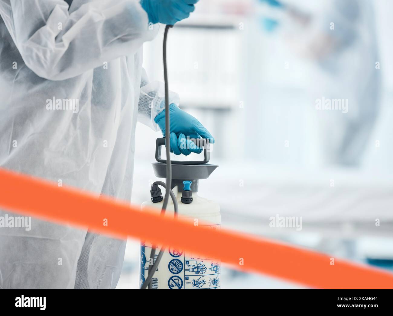 Reinigung, Desinfektion und Person im Gefahrgutanzug im Labor mit Desinfektionsmittel zur Reinigung von Keimen, Virusexposition und Spray. Covid, Hygiene- und Medizinarbeiter Stockfoto