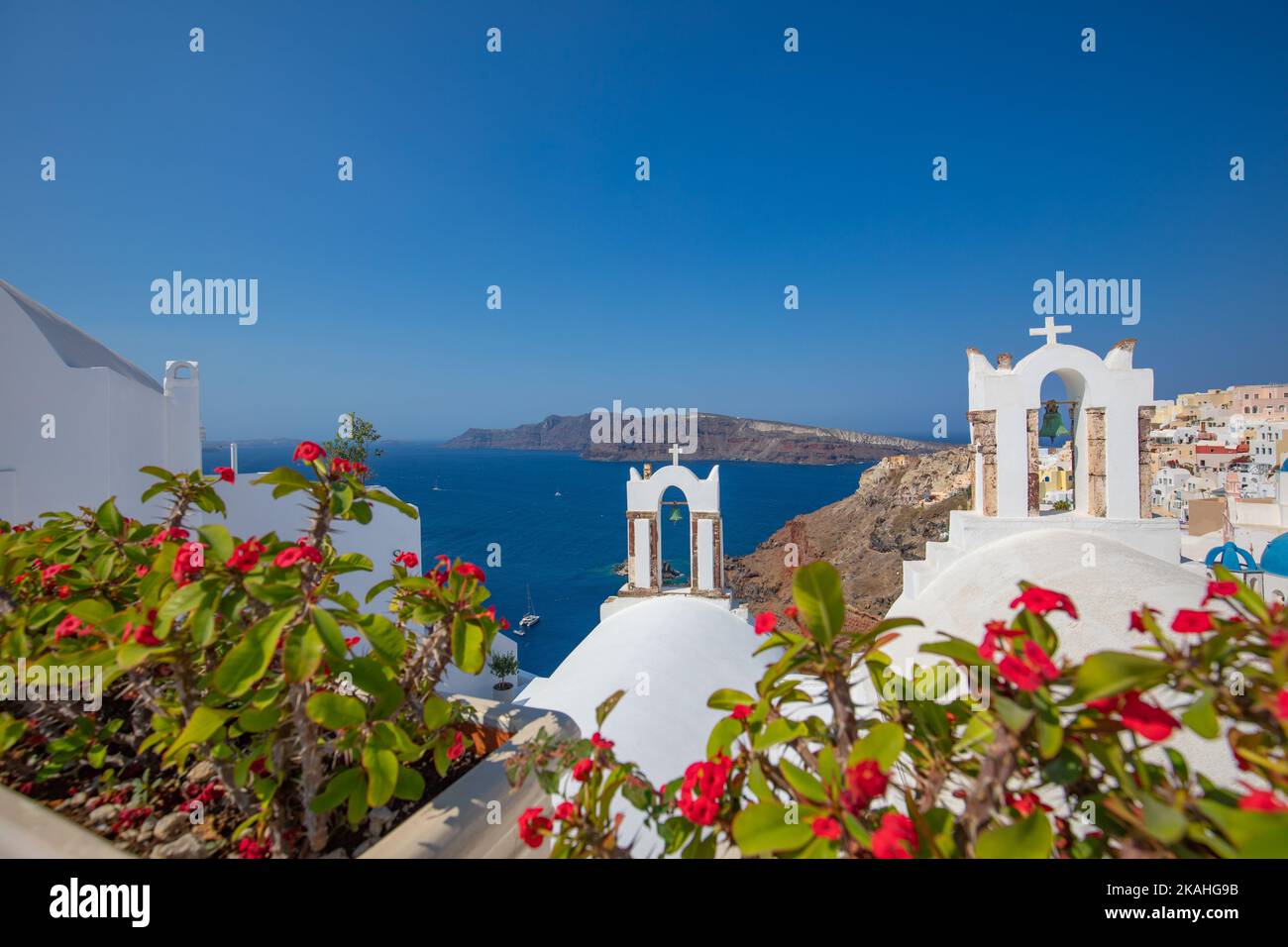 Sommerurlaub Panorama, Luxus berühmten Europa Ziel. Weiße Architektur in Santorini, Griechenland. Perfekte Reiseszenerie mit rosa Blumen Stockfoto
