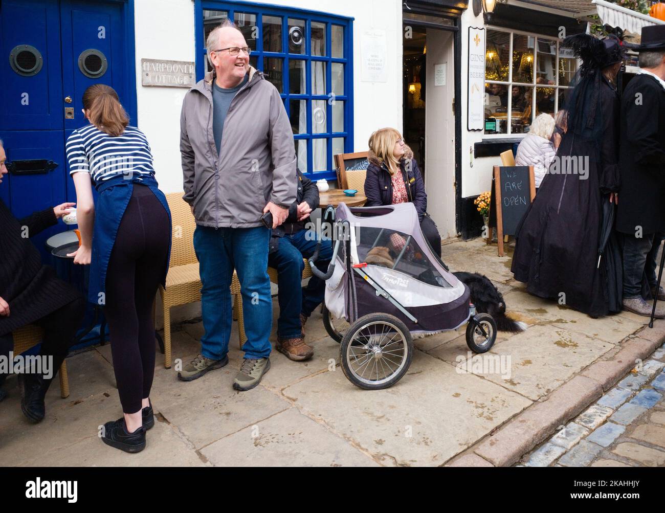 Cafe in Church Street, Whitby während des geschäftigen Gothundwochenendes mit Hund im Kinderwagen Stockfoto