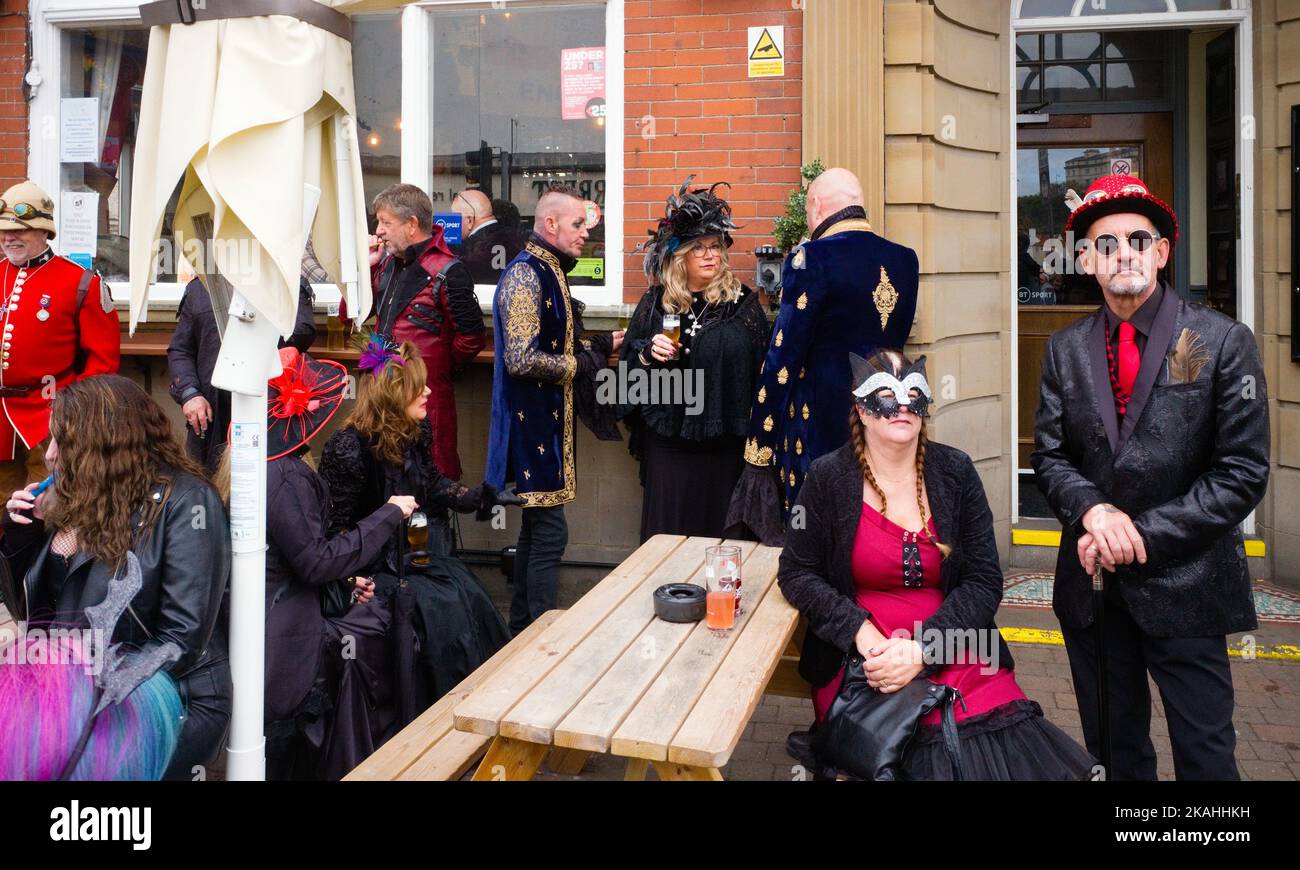Leute, die sich während des Goth-Wochenendes verkleiden und vor einem Whitby Pub stehen Stockfoto
