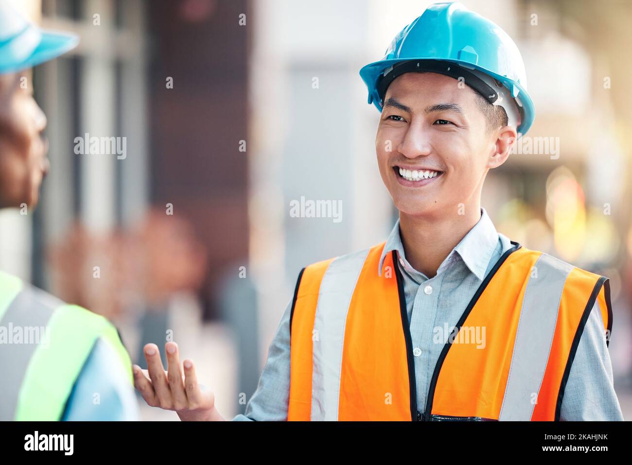 Architektenteam im Gespräch, Zusammenarbeit und Teamarbeit bei der Baustellenplanung Baustrategie. Ingenieure arbeiten zusammen an Plänen, lächeln oder Stockfoto