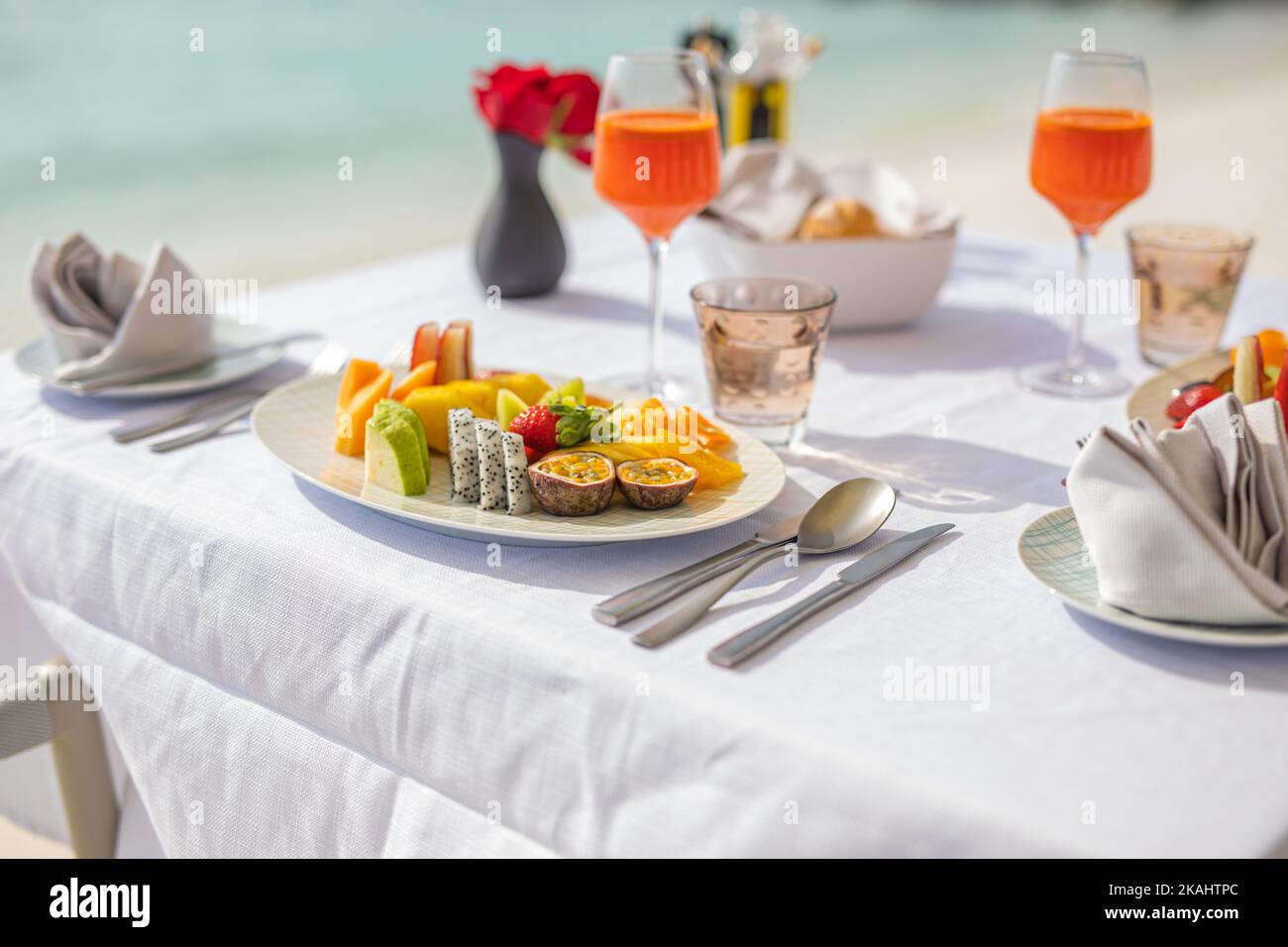 Luxuriöses Frühstück Essen auf weißem Tisch, mit wunderschönem tropischen Meerblick im Hintergrund, morgendlicher Sommerurlaub und romantischem Urlaubskonzept, Luxus Stockfoto