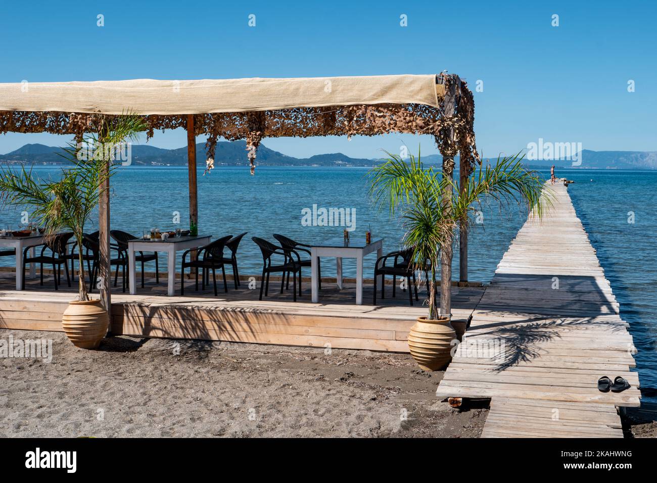 Der Steg, die Promenade, der Pier, vor der Taverna Petrakis am Strand von Paralia Alikes (Molos) auf Korfu. Stockfoto