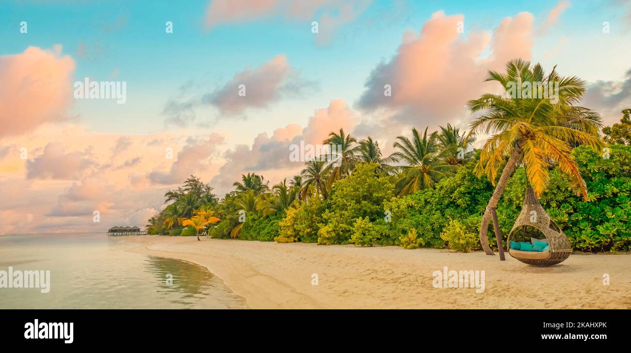Landschaft des paradiesischen tropischen Inselstrandes, Sonnenaufgang, Sonnenuntergang, landschaftlich schöner Blick. Palmen mit entspannter Strandnatur, Ozeanlagune und farbenprächtiger Wolkenhimmel Stockfoto