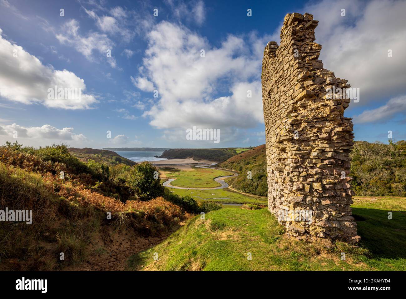 Teil der zerstörten Außenmauer von Pennard Castle mit Blick auf Three Cliffs Bay, Gower Peninsula, Wales Stockfoto