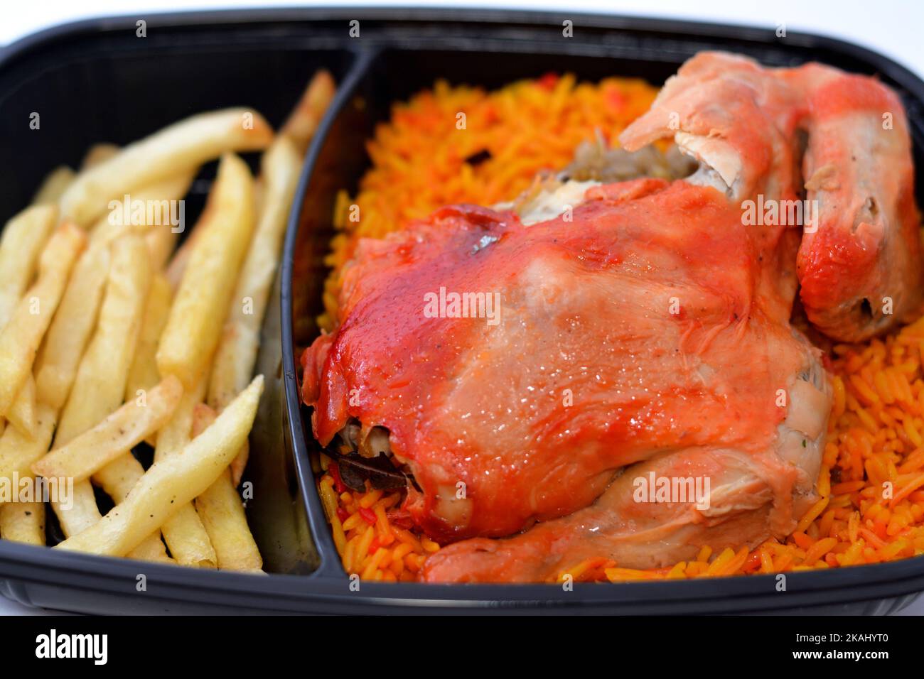 Huhn-Mandi mit langem Basmati-Reis und pommes frites, serviert mit Tomaten-Dakos-Sauce, selektive Fokus des Jemen Rezept von Mandi-Huhn mit Gewürzen und Stockfoto