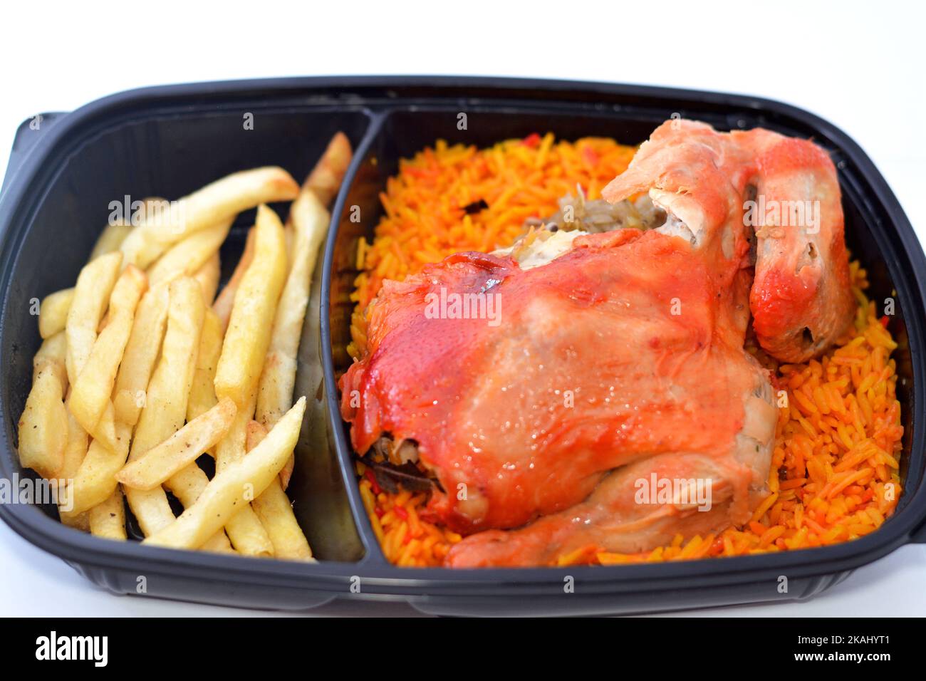 Huhn-Mandi mit langem Basmati-Reis und pommes frites, serviert mit Tomaten-Dakos-Sauce, selektive Fokus des Jemen Rezept von Mandi-Huhn mit Gewürzen und Stockfoto