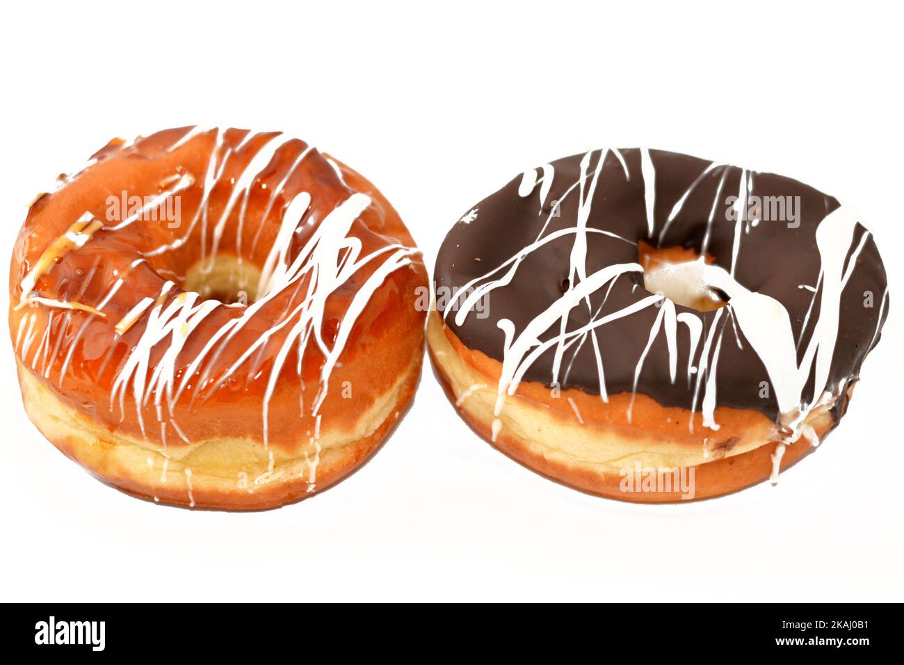 Ringdonuts mit brauner, karamellfarbener und weißer Schokoladensauce, Glasierte, Hefe-gezogene Ringdonuts im amerikanischen Stil, Art von Lebensmitteln aus gesäuertem tief Stockfoto