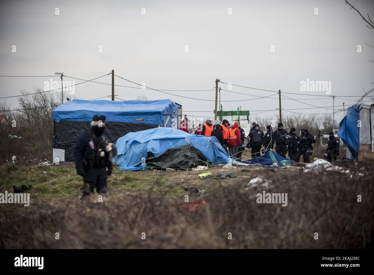 Abbrucharbeiter zerstören eine Hütte, als sie am 01. März 2016 in Calais, Frankreich, einen Teil des „Dschungelcamp“ räumen. Die Behörden kehren aus weiteren Teilen des Flüchtlingslagers „Dschungel“ in Calais zurück, um Flüchtlingsunterkünfte zu räumen und versuchen, Menschen in Transportcontainer auf einem anderen Teil des Geländes zu bringen. Französische Abbruchteams begannen gestern mit dem Abbau von Hütten. Es wird erwartet, dass sich der Widerstand fortsetzt und die Polizei über Nacht Tränengas auf Migranten abfeuerte, die Steine warfen. Ein Gerichtsurteil am Donnerstag billigte einen Plan der französischen Regierung, einen Teil des Geländes zu räumen. Die Behörden sagen, dass etwa 1.000 Migranten betroffen sein werden Stockfoto