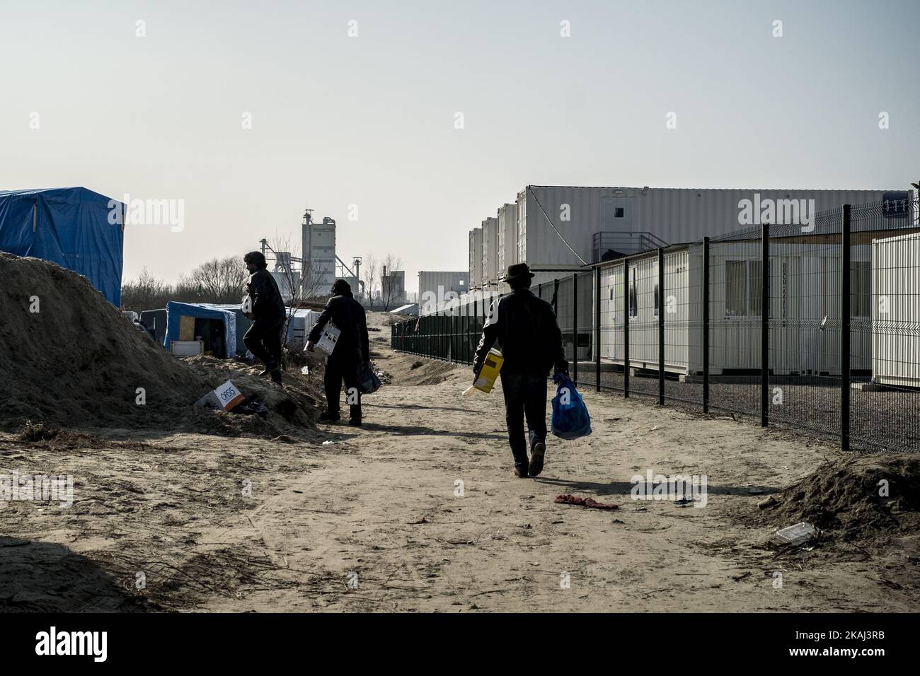 13. März 2016 -Migranten kehren nach dem Paket in ihre Hütten zurück Lebensmittelverteilung durch DEN VEREIN CARE 4 CALAIS. Im Februar gab Ein französisches Gericht die Erlaubnis zum Abriss von Hunderten von Zelten und Holzunterkünften, in denen Migranten und Flüchtlinge in der als Dschungel bekannten Kleinstadt außerhalb von Calais untergebracht sind. Stockfoto