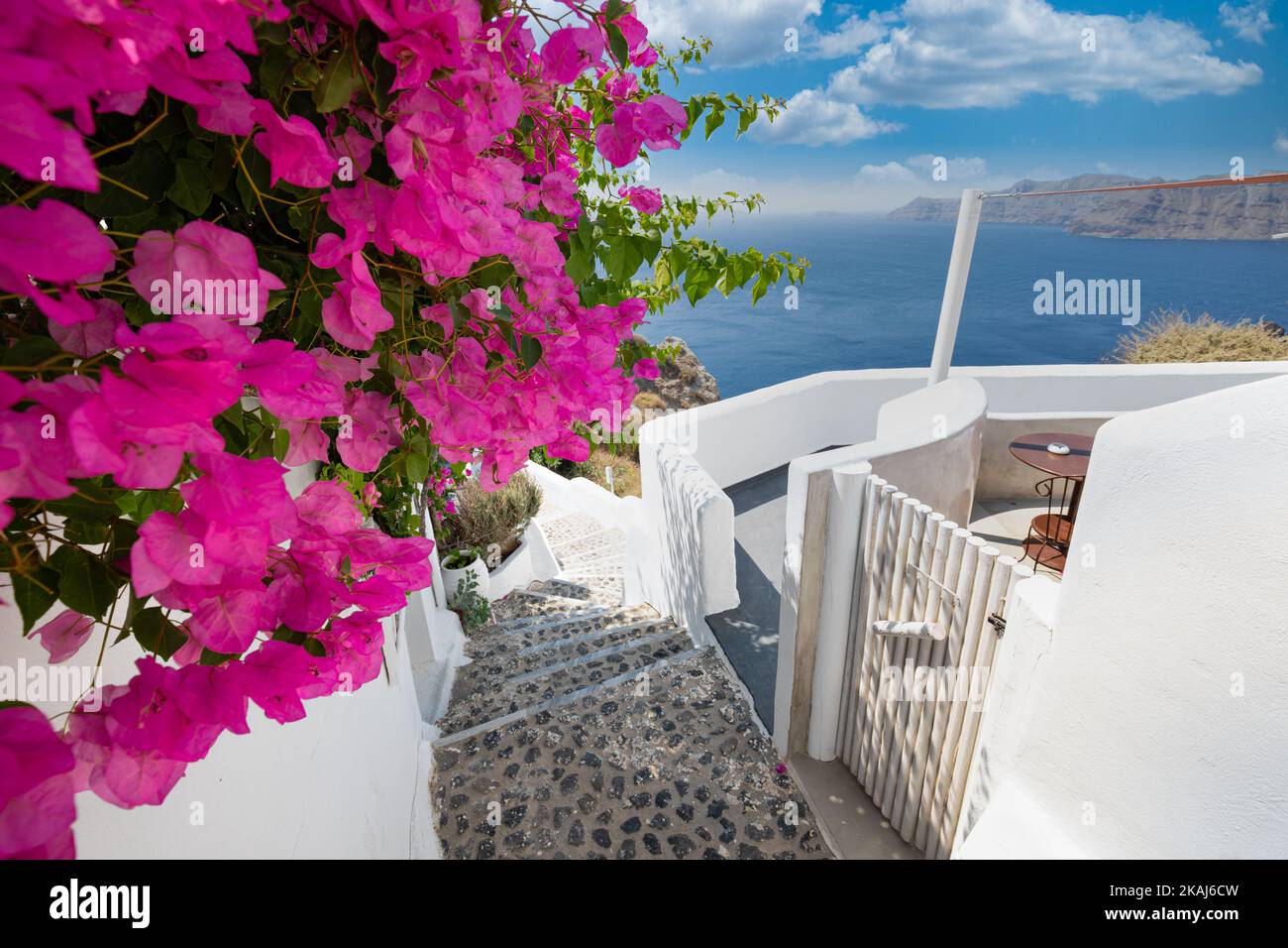 Griechische Insel Santorini. Tolles Reisepanorama, weiße Häuser, Treppen und Blumen auf den Straßen. Idyllischer Sommerurlaub, Stadtlandschaft, Tourismus Stockfoto