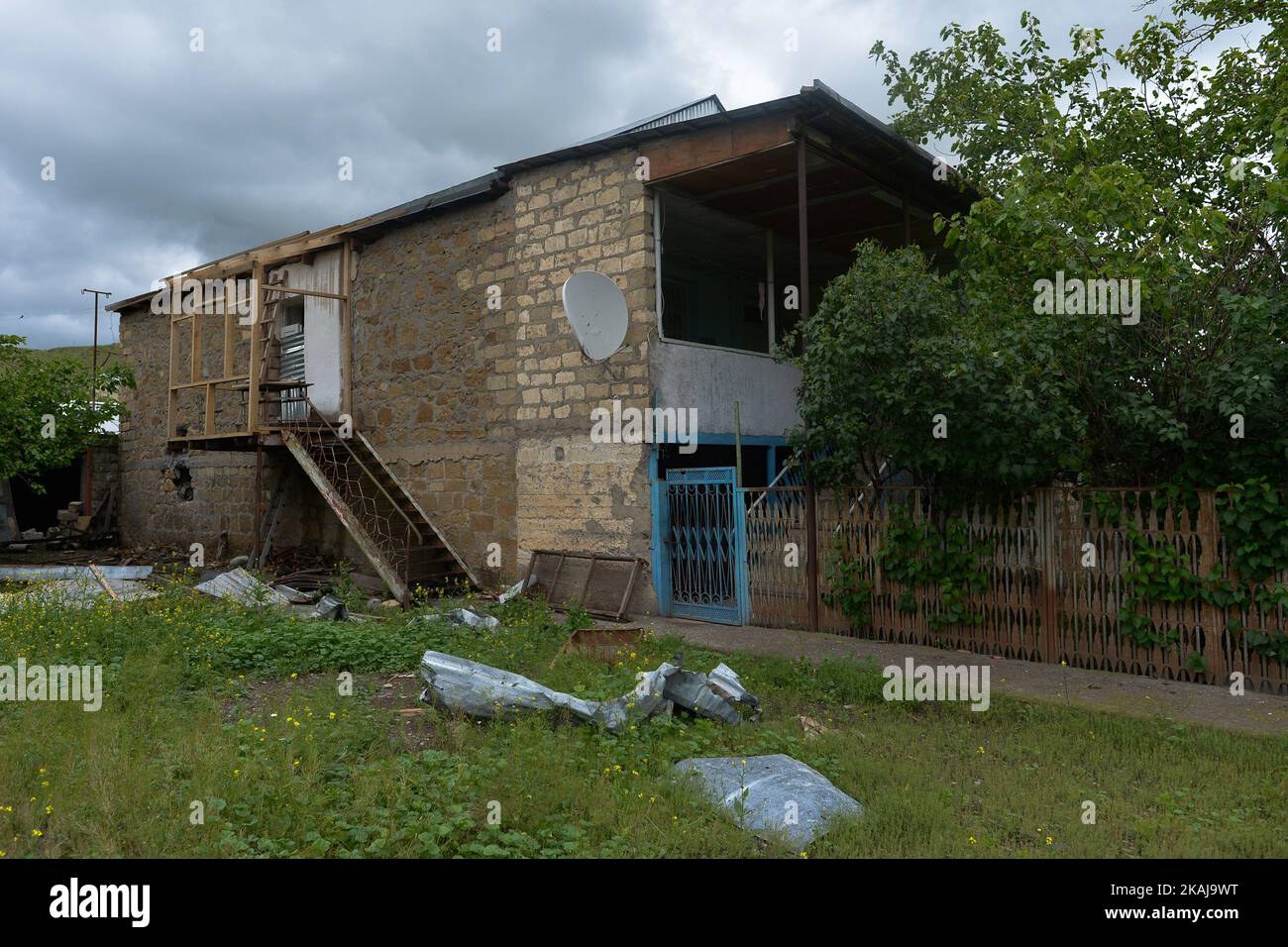 Eine allgemeine Ansicht des halb zerstörten Hauses in Mataghis, einem Dorf in der Nähe der Grenze zwischen Karabkh und Aserbaidschan, in dem Olya Hakobyan und ihr Mann vor den Bombardierungen Aserbaidschans in der Nacht vom 27-28. Auf den 26. April 2016 lebten. Das Ehepaar überlebte die Katastrophe, wurde evakuiert und vorübergehend in ein Hotelzimmer in Stepanakert gebracht. Beide vermissen ihr Haus, und der Ehemann kehrte gerade in das Dorf zurück, um mit den Wiederaufbauarbeiten innerhalb und um ihr Haus herum zu beginnen. Dies ist das zweite Mal, wenn das Paar wieder mit dem Wiederaufbau ihres Hauses beginnen muss, nach dem frühen Stockfoto