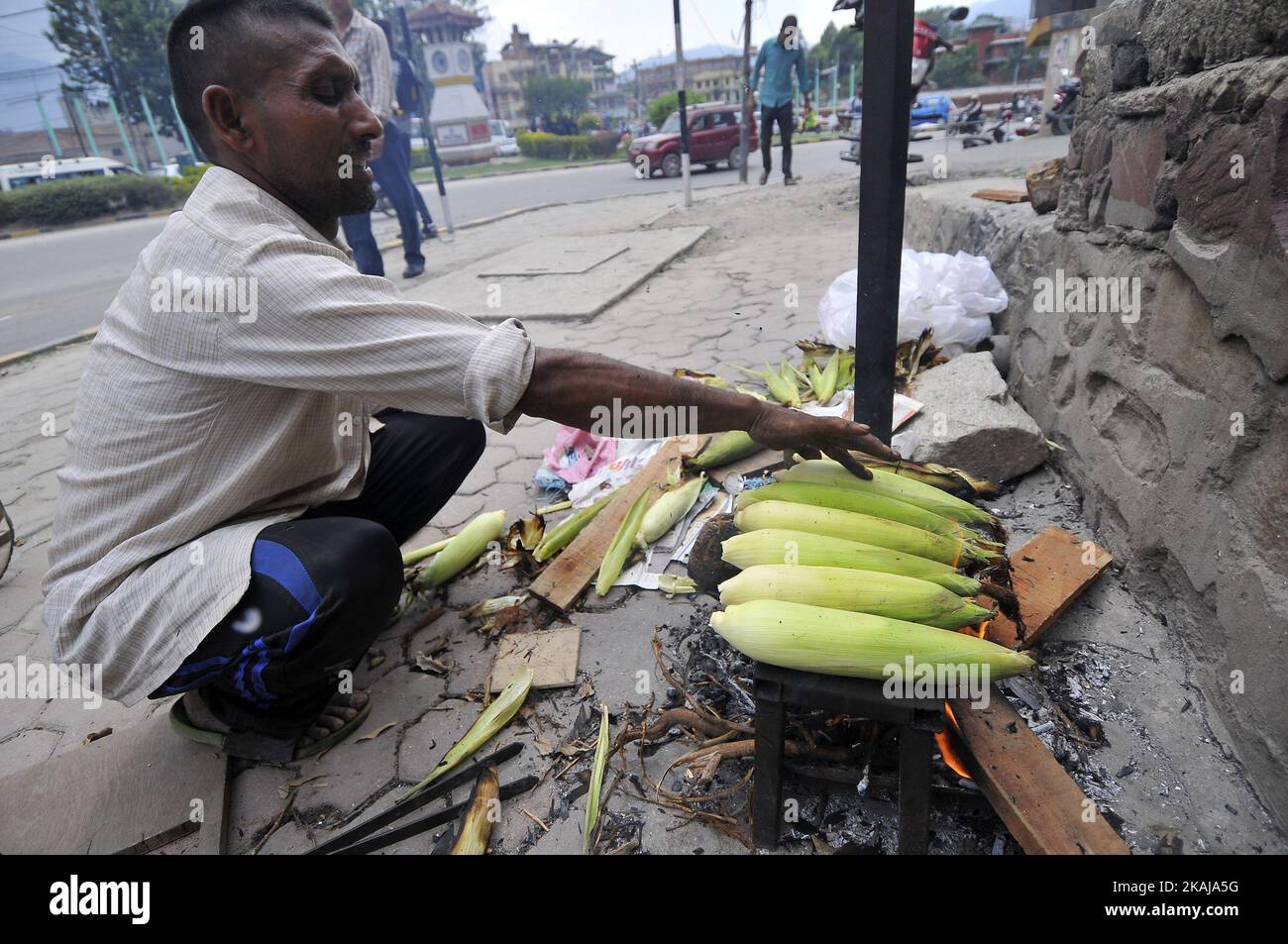 Pashupati Khatri, 45 Jahre alt, ständiger Bewohner von Ramechhap, röstet am 1. Juni 2016 mit Hilfe des Holzfeuers in Kathmandu Mais. Er verwendete Rohmais bei NRS kaufen. 15 (0,15 US-Dollar) pro Stück und verkaufte es dann nach dem Rösten zu 25 (0,25 US-Dollar) pro Stück, und er pflegte NRS zu verdienen. 500 (5,00 US-Dollar) pro Tag. (Foto von Narayan Maharjan/NurPhoto) *** Bitte nutzen Sie die Gutschrift aus dem Kreditfeld *** Stockfoto