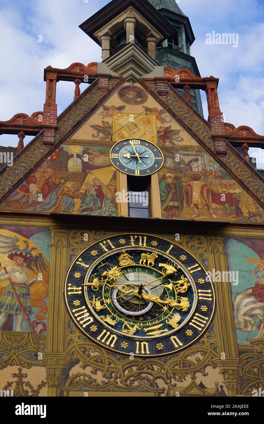 Ein schöner Blick auf den Uhrenturm des Ulmer Rathauses in Deutschland mit heraldischen Symbolen und Wandmalereien an der Wand Stockfoto