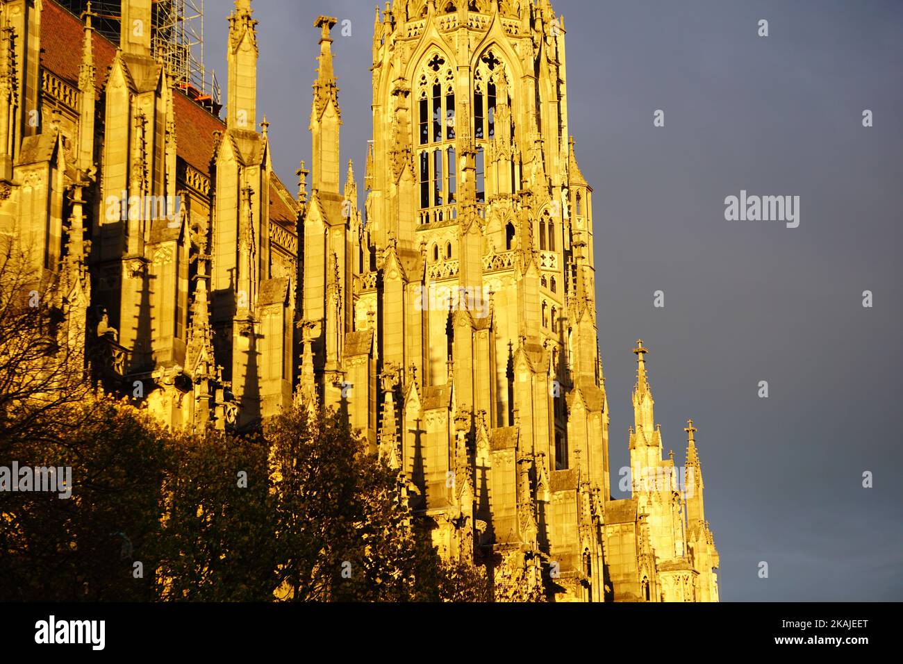 Eine wunderschöne Aussicht auf das Ulmer Münster in Ulm, Deutschland mit goldenem Sonnenlicht unter einem dunklen bewölkten Himmel Stockfoto