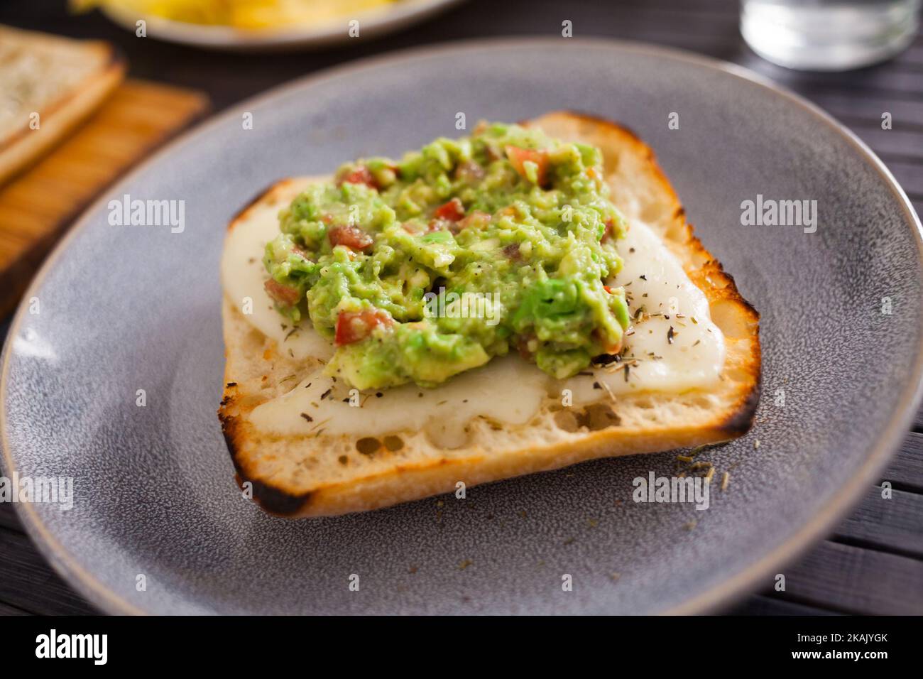 Gesundes Frühstück. Getoastetes italienisches Ciabatta-Brot mit geschmolzenem Käse und Avocado-Püree Stockfoto