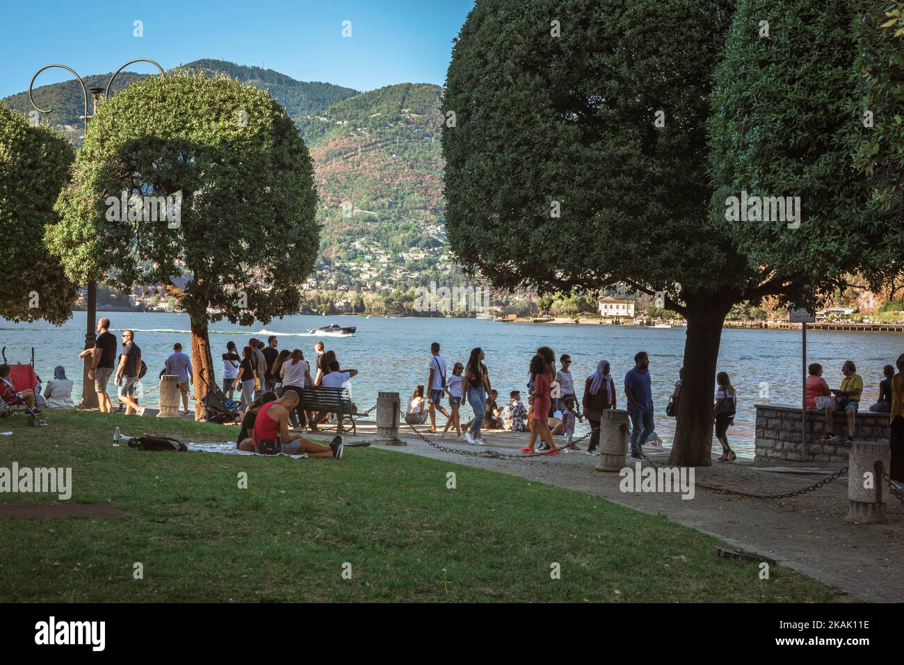 Comer See, Seeblick im Sommer von Menschen zu Fuß in den Stadtgärten von Como - die Giardini del Tempiano Voltiano, Lombardei, Italien Stockfoto