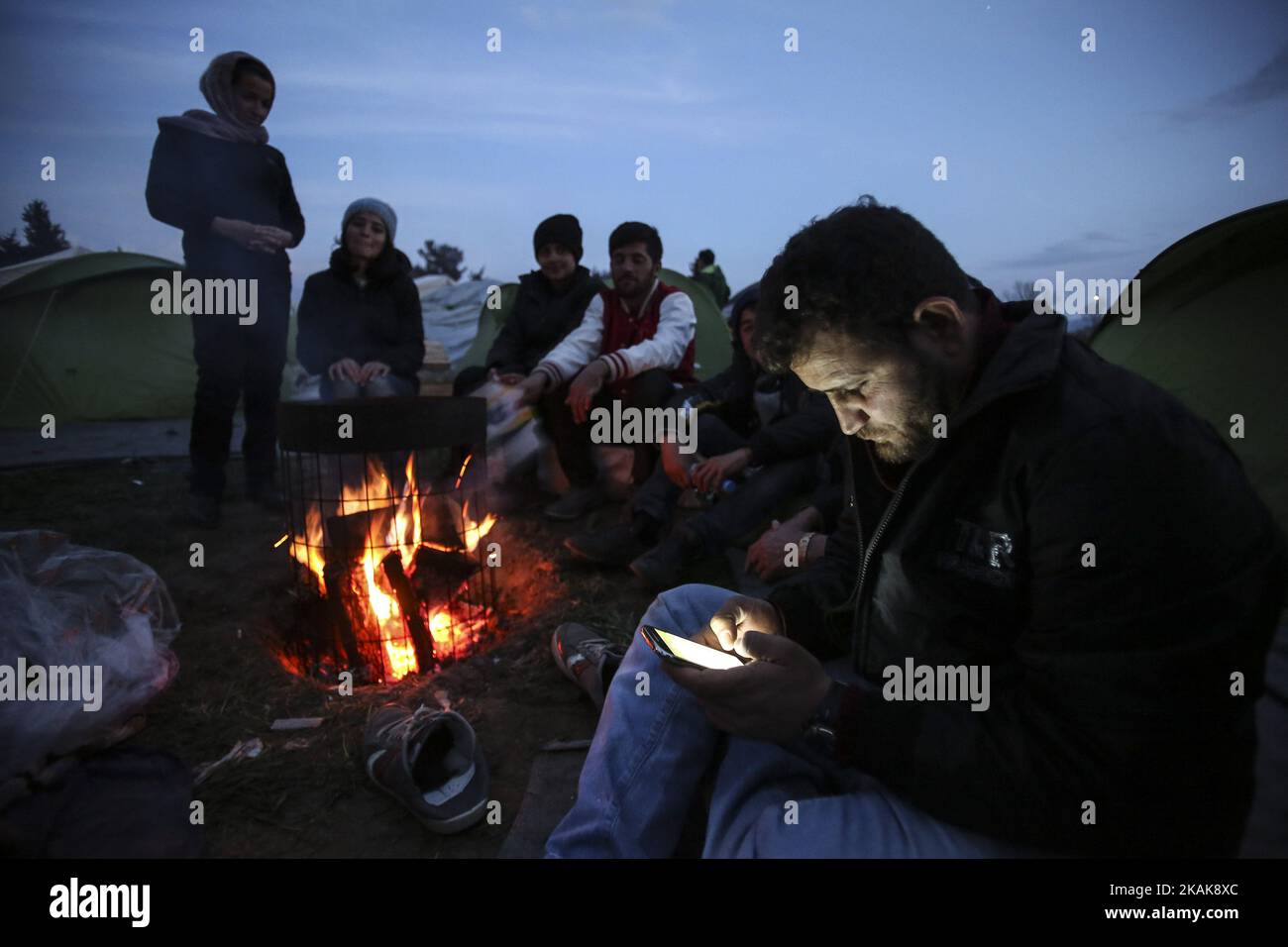 Flüchtlinge und Migranten versuchen, sich durch Brände im provisorischen Lager in Idomeni, Griechenland, zu erwärmen Februar 2016. Sie nutzen alles, um das Feuer zu halten, sogar Kunststoffe, was eine schreckliche und giftige Atmosphäre schafft. Flüchtlinge sind an der Grenze gestrandet, da der illegale Bahnpass gesperrt ist. Seit 2014 strömen Flüchtlinge aus Syrien, dem Irak, aber auch aus Afghanistan, Pakistan und anderen Ländern des Nahen Ostens nach Idomeni, um die griechischen Grenzen zu überqueren und in die ehemalige jugoslawische Republik Mazedonien einzureisen. Sowohl Letzteres als auch Serbien im Norden sind aus dem Schengen-Raum, weshalb das Refug Stockfoto