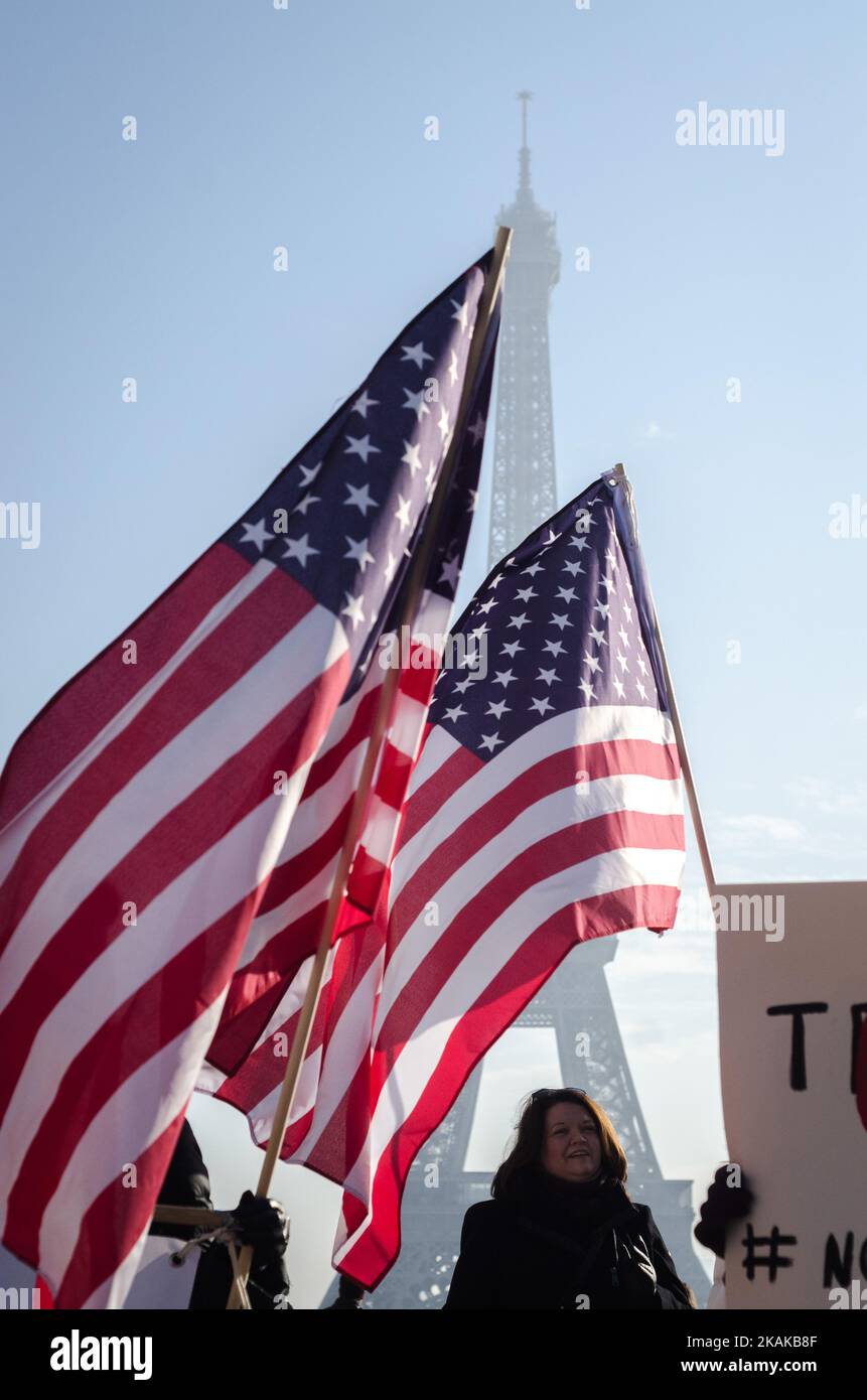 Ein Demonstrator trägt eine amerikanische Flagge während einer Kundgebung in Solidarität mit den Anhängern des Marsches der Frauen in Washington und vielen anderen Städten am 21. Januar 2017 vor dem Eiffelturm in Paris, einen Tag nach der Amtseinführung von US-Präsident Donald Trump. In mehr als 30 Ländern der Welt fanden Protestkundgebungen statt, die sich solidarisch mit dem Washingtoner Frauenmarsch zur Verteidigung der Pressefreiheit, der Frauen- und Menschenrechte nach der offiziellen Amtseinführung von Donald J Trump als Präsident der Vereinigten Staaten von Amerika im Jahr 45. zeigten. (Foto von Julien Mattia/NurPhoto) *** Bitte nutzen Sie die Gutschrift Stockfoto