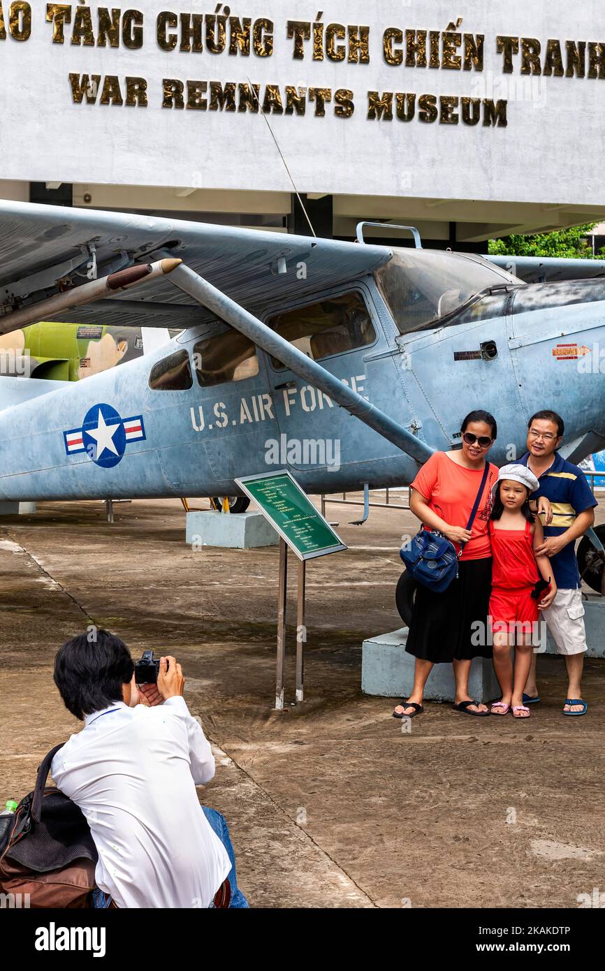 Vietnamesische Besucher posieren für Fotos vor dem Kriegsflugzeug der US-Luftwaffe, war Remnants Museum, Ho Chi Minh City, Vietnam Stockfoto
