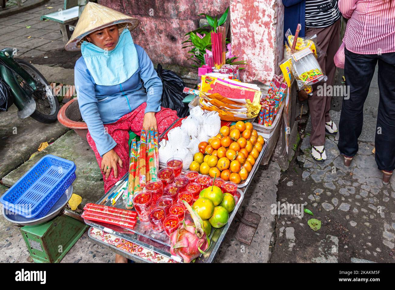 Vietnamesische Dame mit Bambushut, die Obst und Gemüse auf dem Straßenmarkt in Ho Chi Minh City, Vietnam verkauft Stockfoto