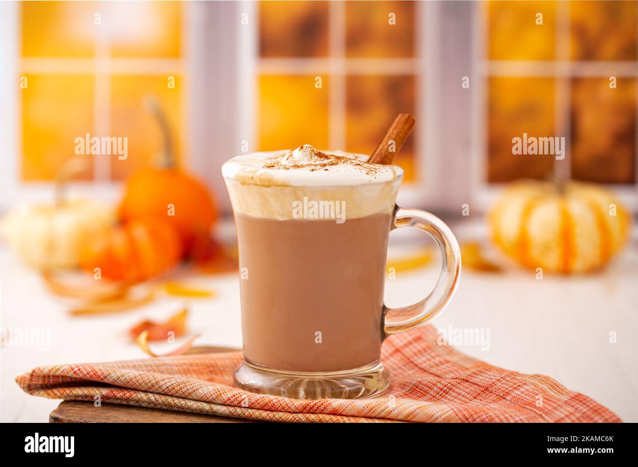 Kürbis-Latte auf Pflanzenbasis mit milchfreier Schlagsahne aus Kokosnuss und Zimt in einer festlichen Herbstküche Stockfoto