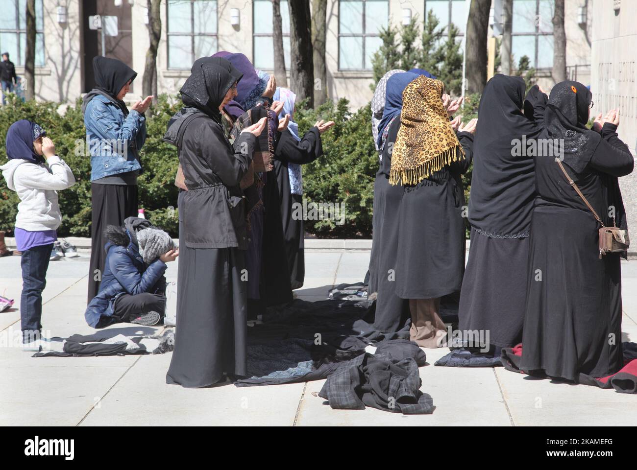 Muslimische Frauen beten während eines Protestes gegen die Entscheidung von US-Präsident Donald Trump, am 8. April 2017 in Toronto, Ontario, Kanada, Luftangriffe gegen Syrien zu starten. Demonstranten versammelten sich vor dem amerikanischen Konsulat in Toronto, um die Luftangriffe gegen das syrische Regime in dieser Woche zu verurteilen. Die USA haben zum ersten Mal seit Beginn des Bürgerkriegs einen Raketenangriff auf Syrien gestartet, der auf einen Luftwaffenstützpunkt in der kleinen Stadt Idlib abzielte, von dem die Vereinigten Staaten behaupten, dass der Chemiewaffenangriff auf Zivilisten in dieser Woche vom Regime von Baschar al-Assad gestartet wurde. (Foto von Creative Touch Imaging Stockfoto