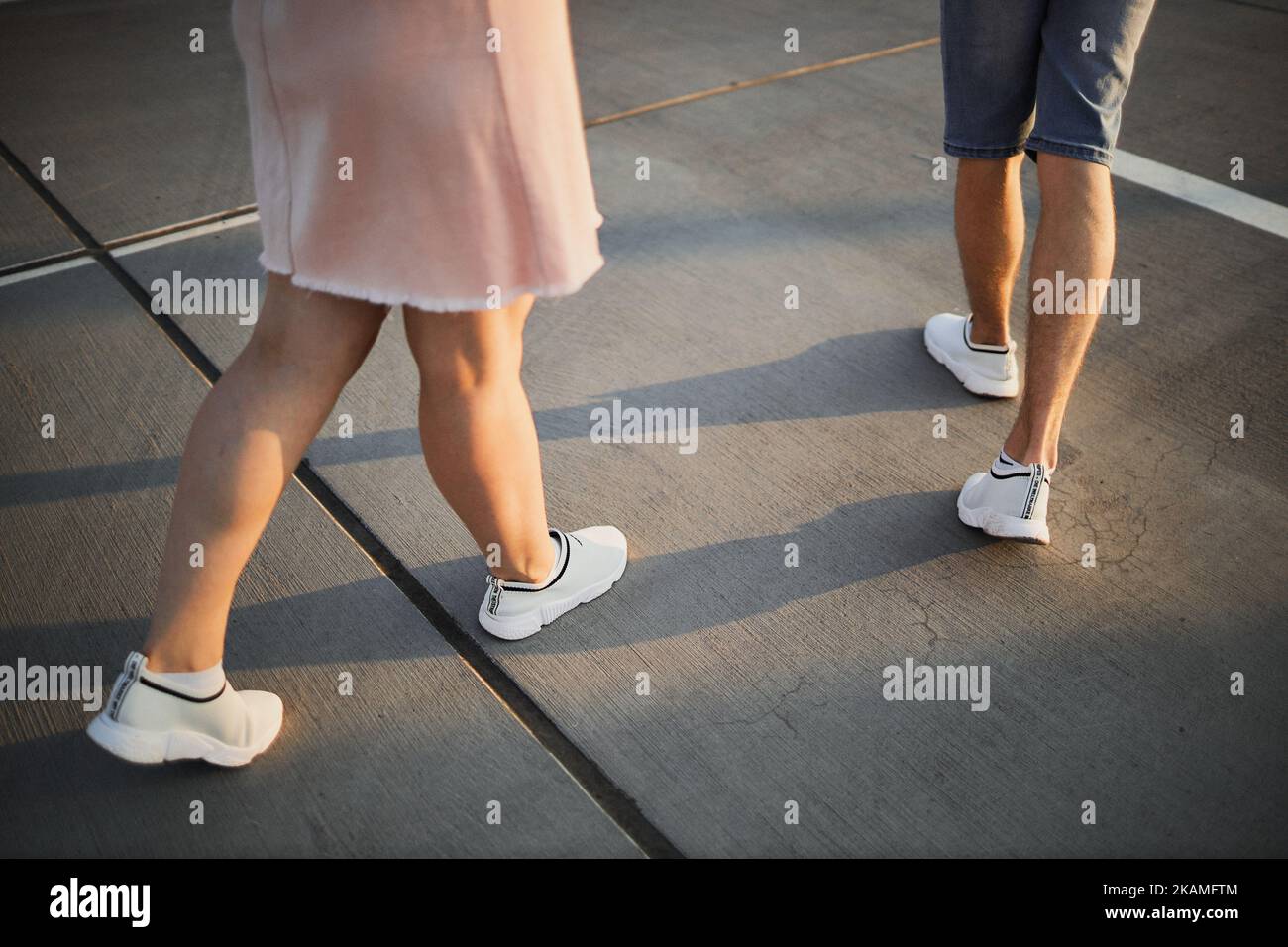 Beine eines Mannes und einer Frau bei Sonnenuntergang. Stockfoto