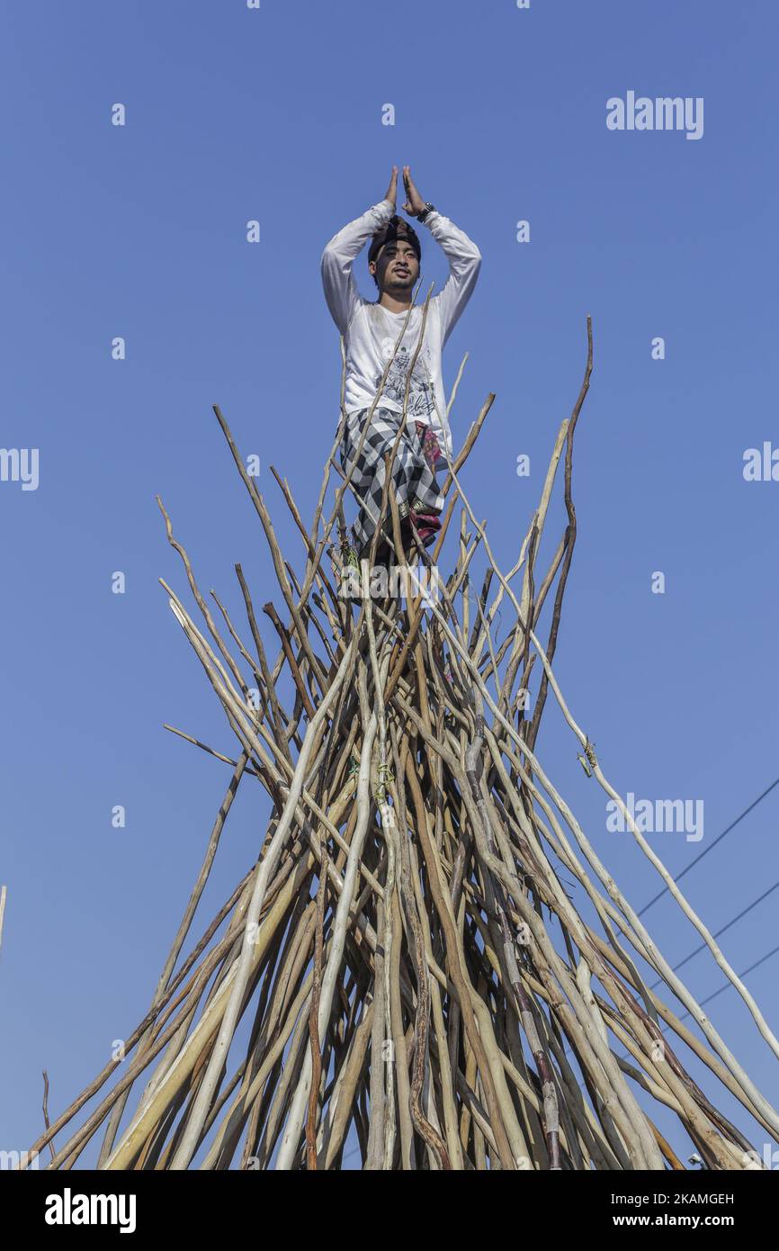 Ein Mann steht auf einer hölzernen Pyramide aus Stäben während des Mekotek-Rituals, das von balinesischen Hindus im Dorf Munggu am 15. April 2017 in Badung, Bali, Indonesien, praktiziert wurde. Das Mekotek-Ritual ist eine traditionelle Zeremonie im Dorf Munggu, bei der der symbolische Sieg des Guten (Dharma) gegen das Böse (Adharma) gefeiert wird, bei dem die Teilnehmer wiederholt auf eine hölzerne Pyramide aus Stäben klettern, wie sie von Zelebranten von einem Tempel zum anderen getragen wird. (Foto von Johanes Christo/NurPhoto) *** Bitte nutzen Sie die Gutschrift aus dem Kreditfeld *** Stockfoto