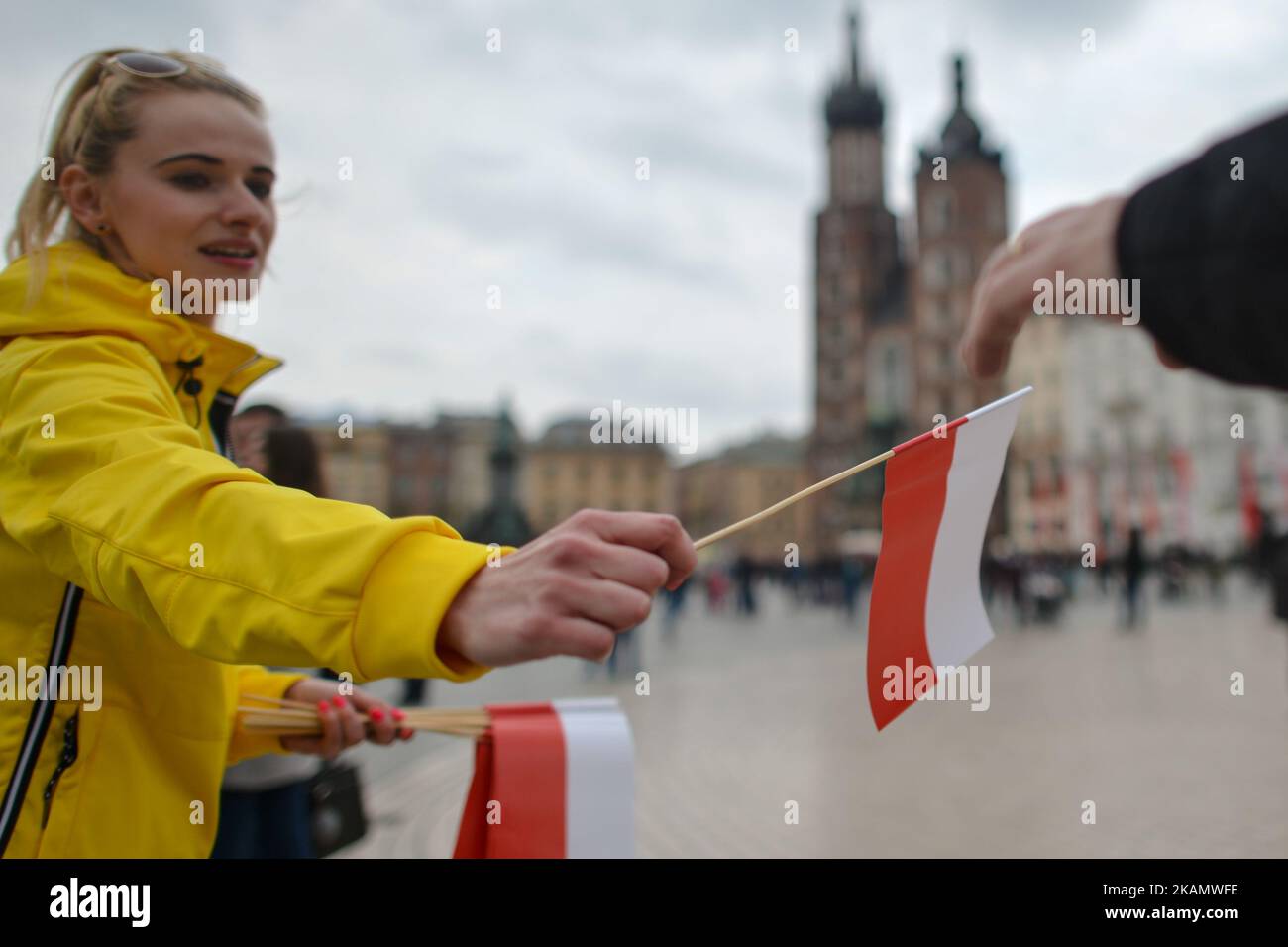 Eine junge Dame zollt am Tag der polnischen Flagge weiße und rote Fahnen. Der Flaggentag wurde 2004 in Polen eingeführt und überbrückt die Lücke zwischen dem Internationalen Arbeitertag am 1.. Mai und dem Tag der Verfassung am 3.. Mai. Heute wurden im ganzen Land Hunderte von verschiedenen Veranstaltungen organisiert, eine davon, die „White and Red Relay RMF FM“. Um 6 Uhr verließ die Staffel mit der polnischen Flagge Hel, im Norden Polens, mit der Flagge, die mit dem Boot in Sopot eintraf, und dann von Danzig nach Warschau mit dem Flugzeug. In der Hauptstadt, der Hauptpunkt des Programms, war ein Relais von Politikern. Eine weitere Station war Krakau, wo die Flagge wieder Stockfoto