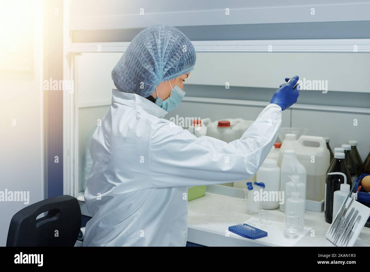 Wissenschaftler oder Laborassistent, der ein Reagenzglas in einem wissenschaftlichen medizinischen Labor hält. Biochemische Forschung und Medizin Stockfoto