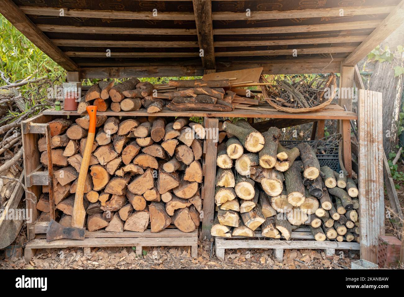Organisierter Holzschuppen vorbereitet, um das Holz im Kamin im Haus im Winter zu verwenden. Stockfoto