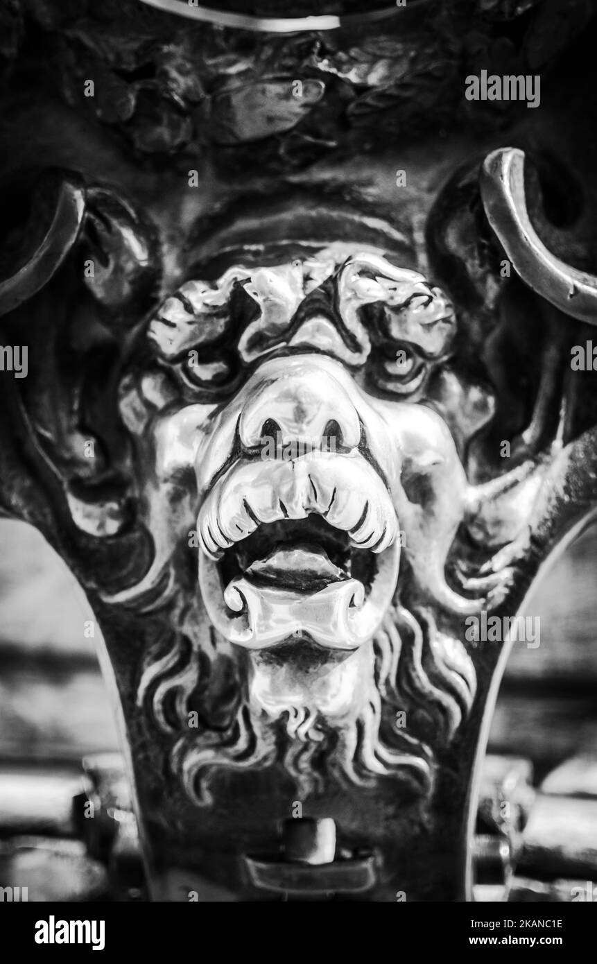 Eine vertikale Graustufenaufnahme eines heidnischen Totems und Glücksbringer mit dem Gesicht eines mythischen mantikors Stockfoto